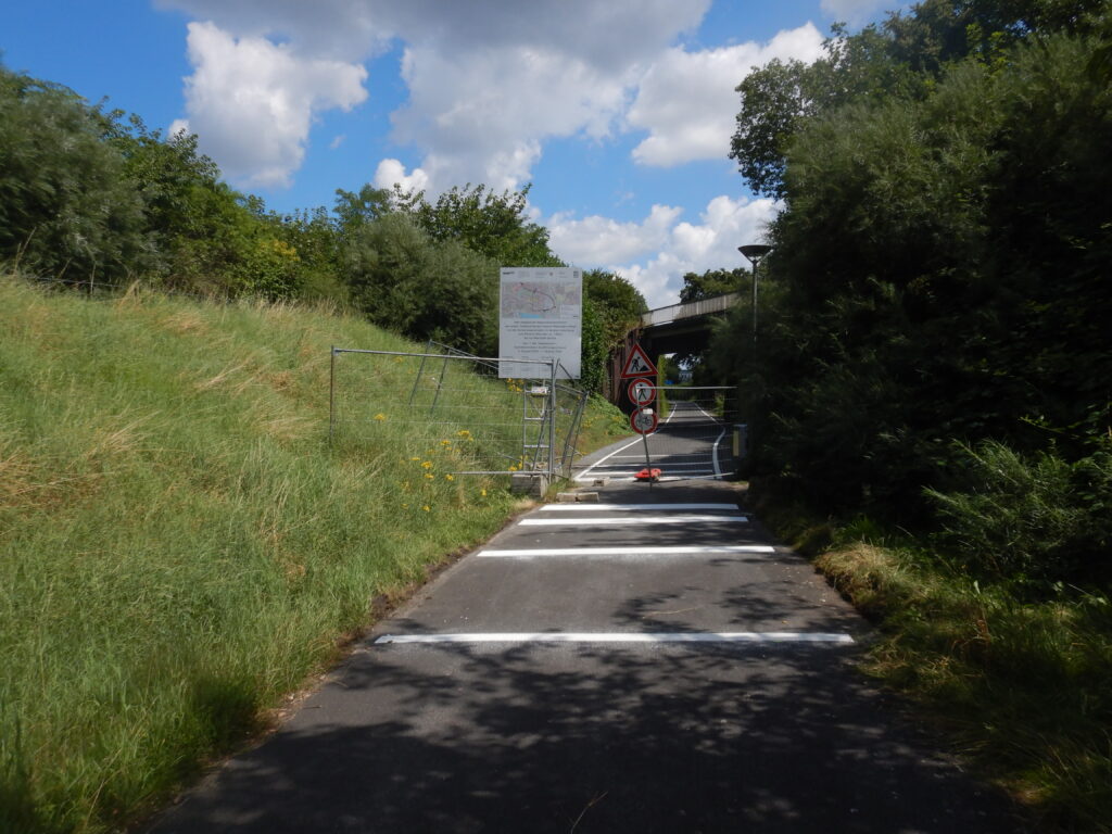 Teilweise verrückte Bauzäune, Bautafel und Verkehrszeichen